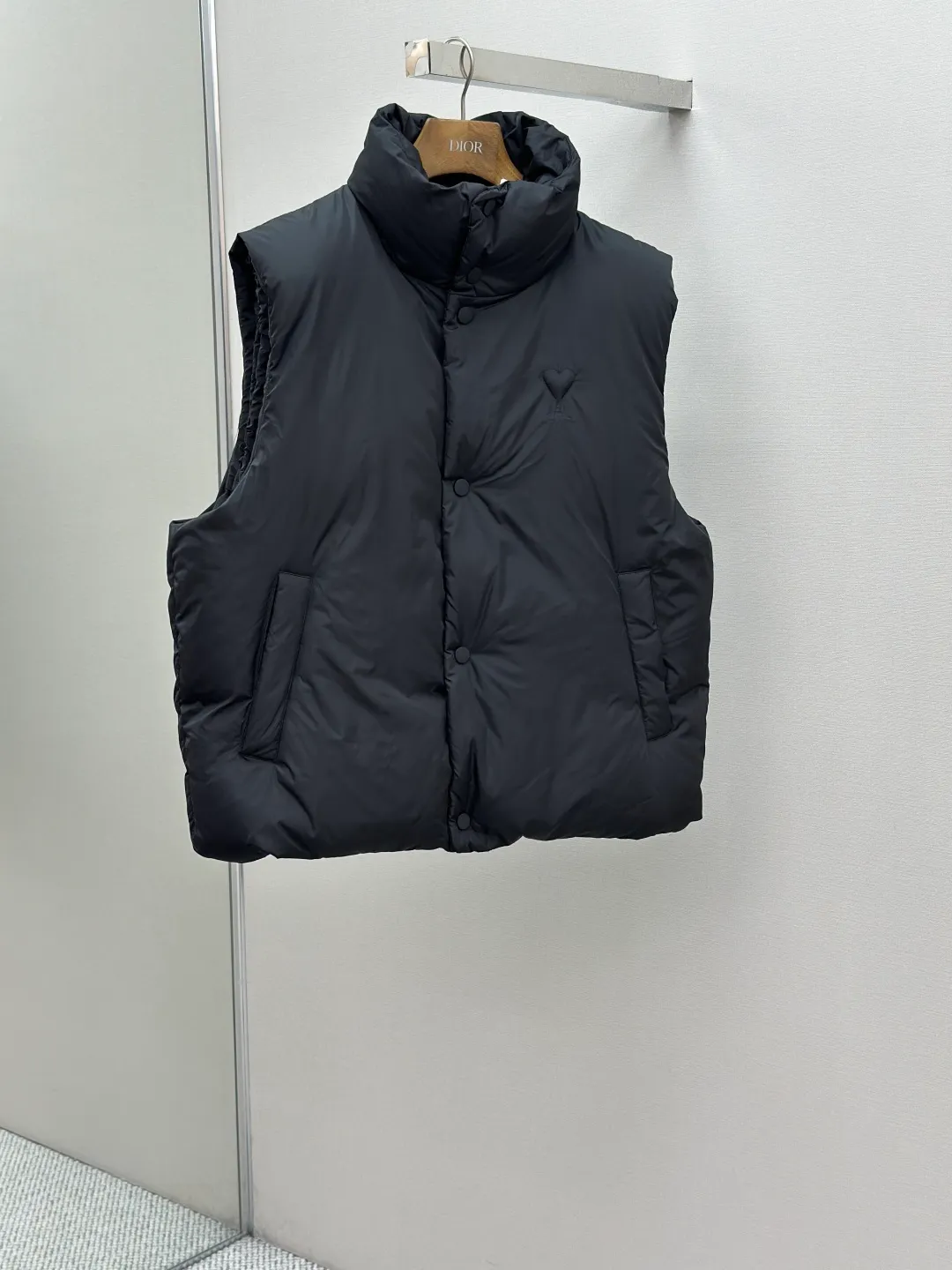 P810 AMIPARIS love padded embroidered down vest Fabric selection: Taffeta fabric woven from 100% polyester fiber. It adopts warp and weft plain weave and is woven very tightly, making the surface of the fabric extremely smooth and flat, with a "skinny" and stiffness that is not easy to collapse. When rubbed or moved around, it will make a unique, crisp "rustling" sound. At the same time, it has a delicate plain texture and a soft, elegant silky luster. This kind of luster is not as dazzling as satin, but more restrained and advanced.  Lining selection: Use 100% nylon to create the lining. The high-density and tight weaving process prevents tiny lint from getting out of the gaps in the fabric. The smooth surface improves the putting on and taking off experience, and the excellent wear and tear resistance ensures damage caused by frequent use, while the light and soft texture does not affect the overall weight.  Technology: The fabric and padding material are tightly fixed on the frame of the embroidery machine. The embroidery machine uses sparse stitches along the padding layer to outline the filling area of the pattern, and then runs the overlay layer's padding, using dense stitches to perfectly cover the foam padding layer, thus forming a slightly raised love embroidery, which feels soft and full, enhancing recognition while maintaining a low profile. High-quality filling: It uses 90 white duck down with a weight of 160g to ensure excellent thermal insulation performance. After strict screening and processing, the velvet is not easy to get drilled, ensuring durability.  Accessories: One-to-one customized three-standard, one-to-one customized hem elastic buckle, one-to-one customized snap button SIZE: XS S M L